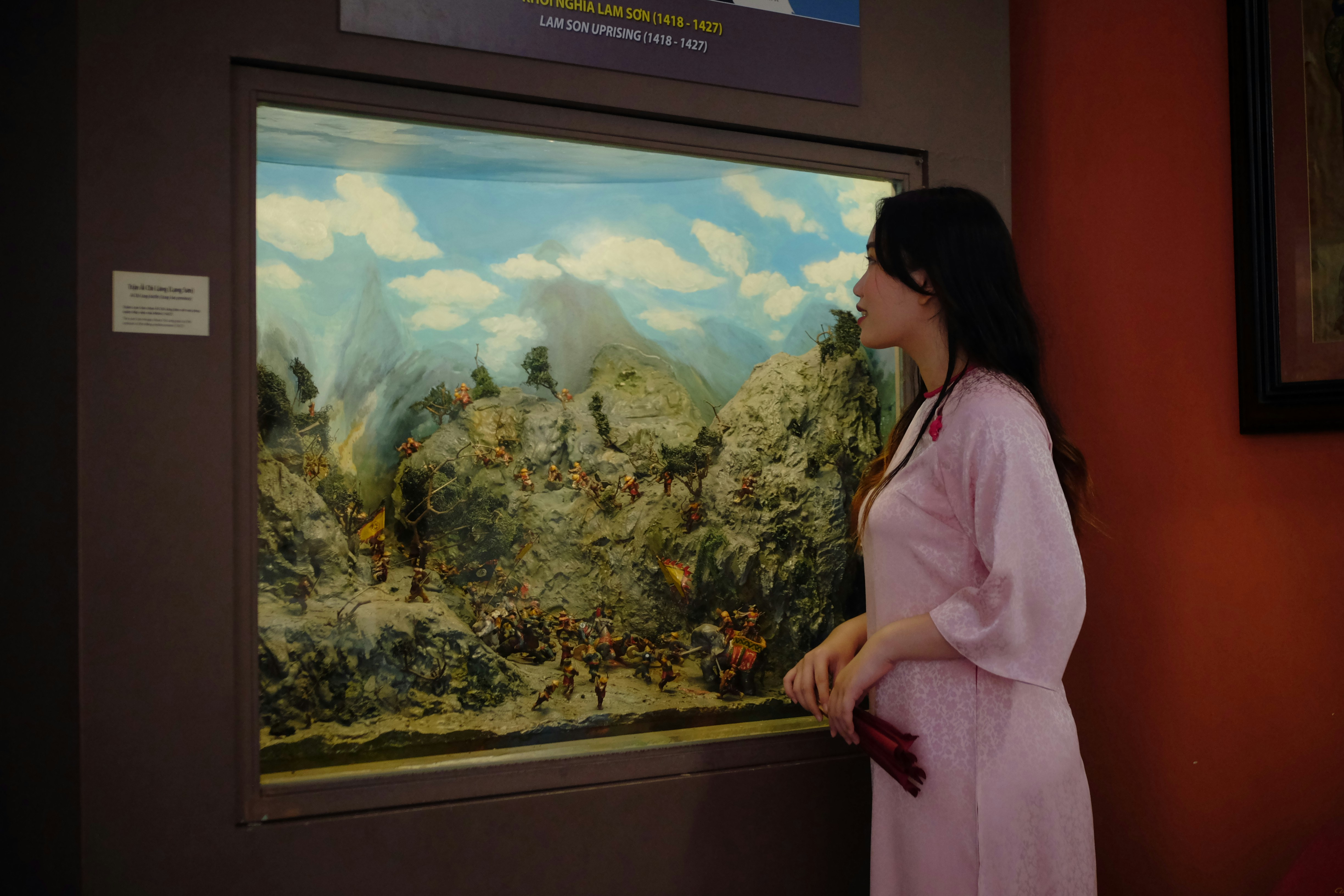 A woman looking at a painting in a museum