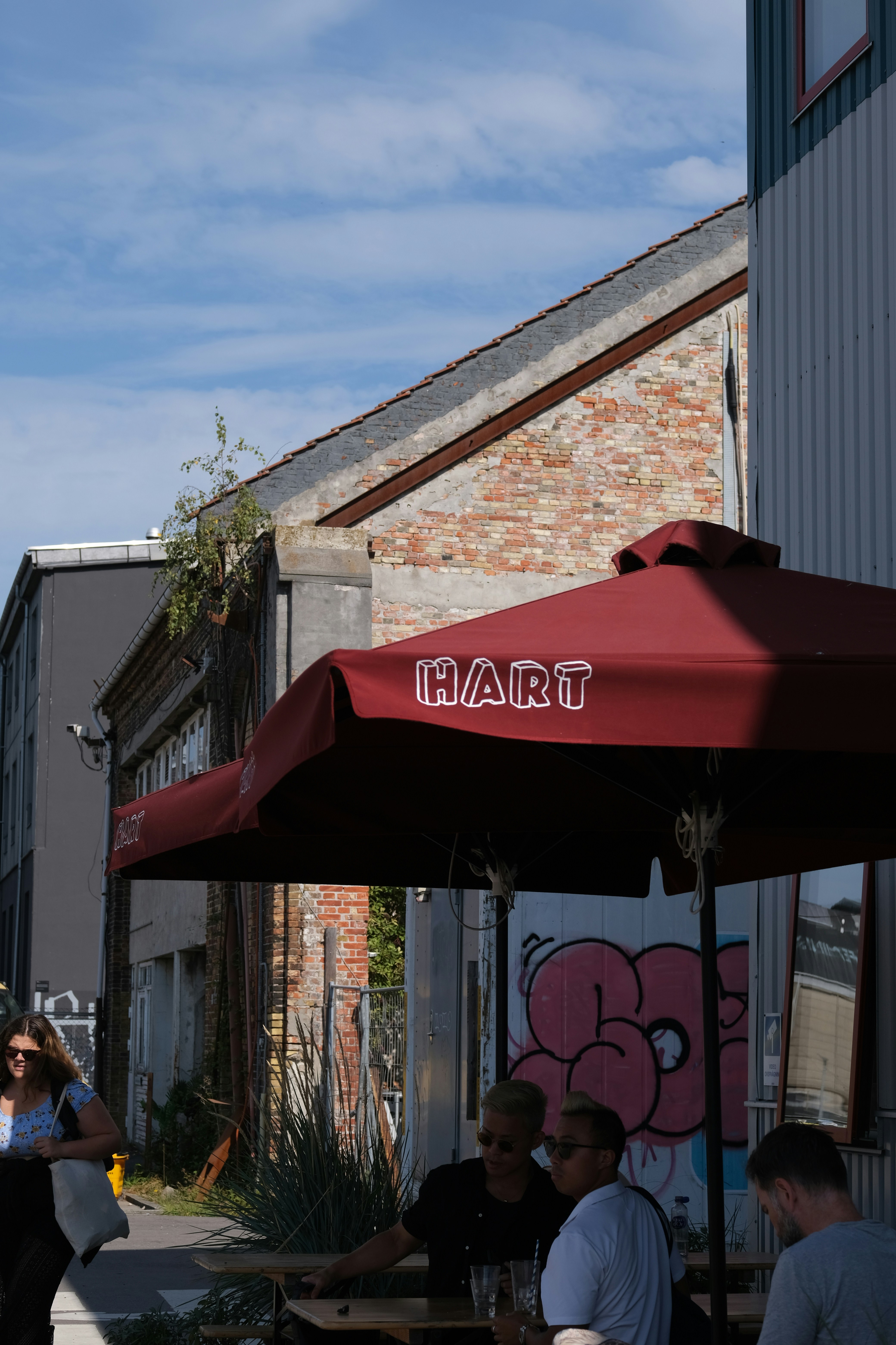 Eine Gruppe von Menschen, die an einem Tisch unter einem roten Regenschirm sitzen