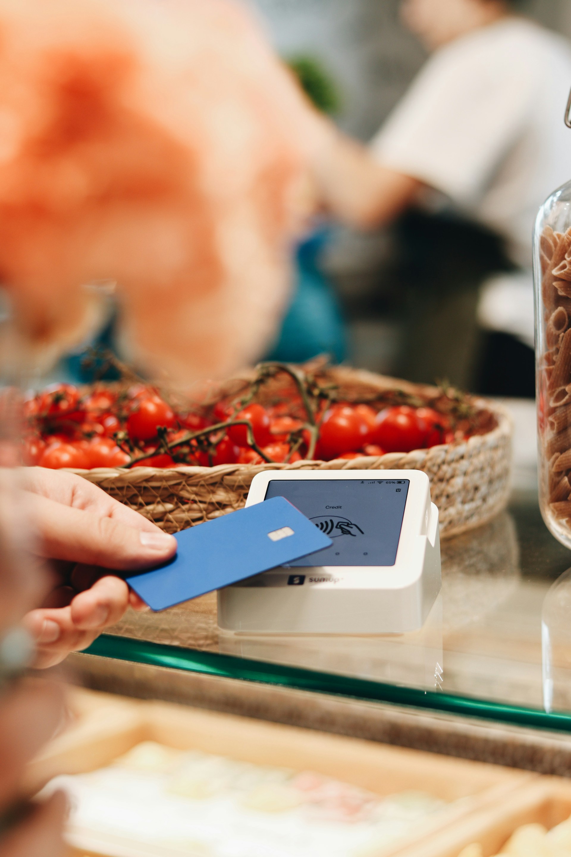 A person holding a credit card at a counter