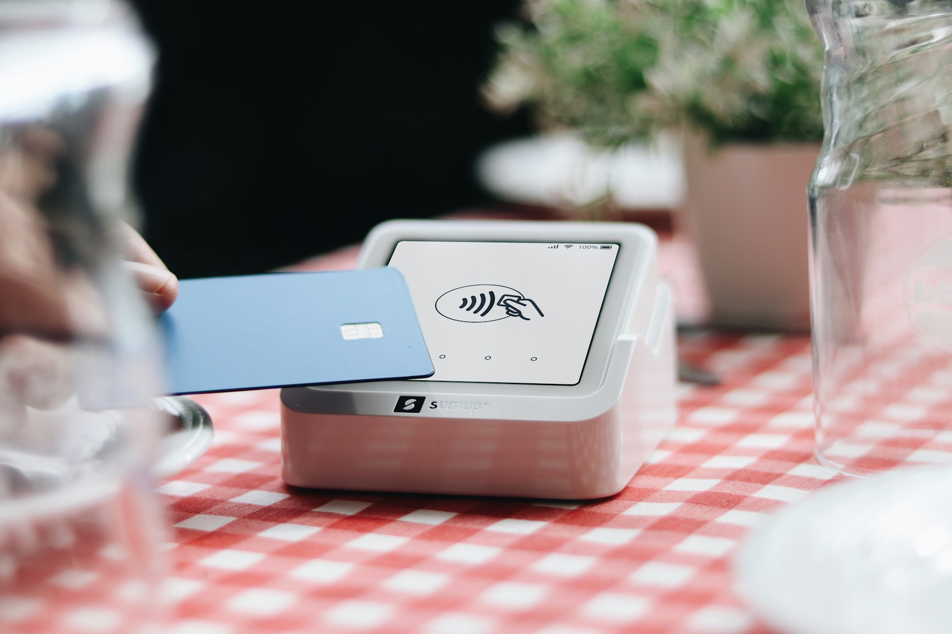 A person holding a credit card at a table