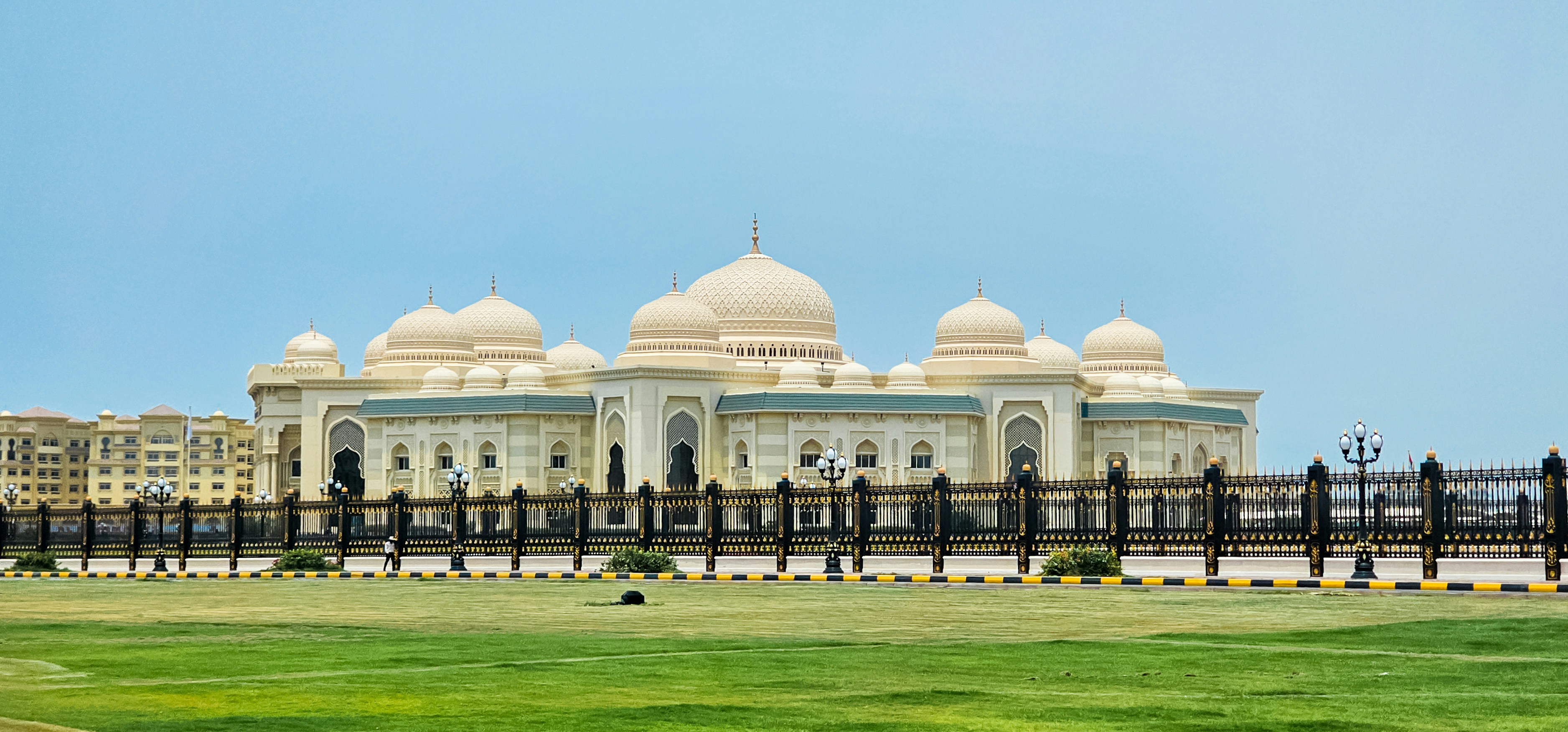A large white building sitting on top of a lush green field
