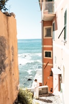 A man sitting on a ledge next to the ocean