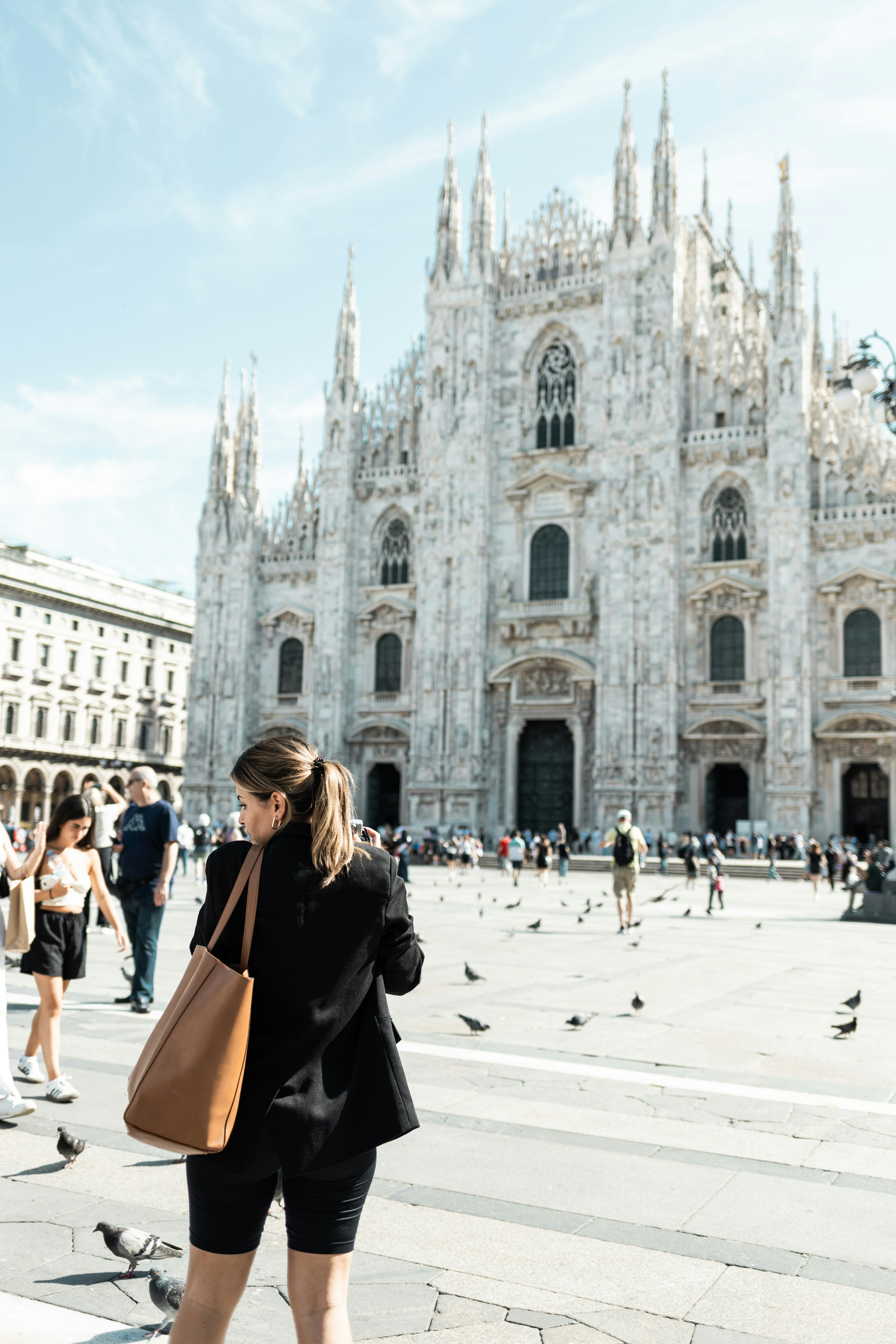 Une femme debout devant une grande cathédrale