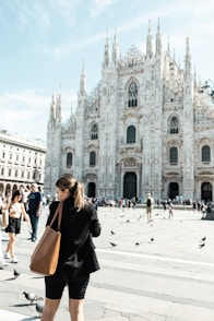 A woman standing in front of a large cathedral