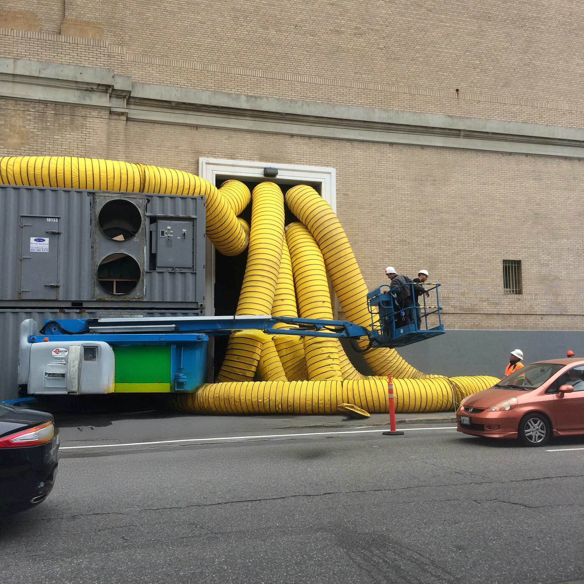 A trailer-mounted drying unit feeding yellow ducting into a commercial building