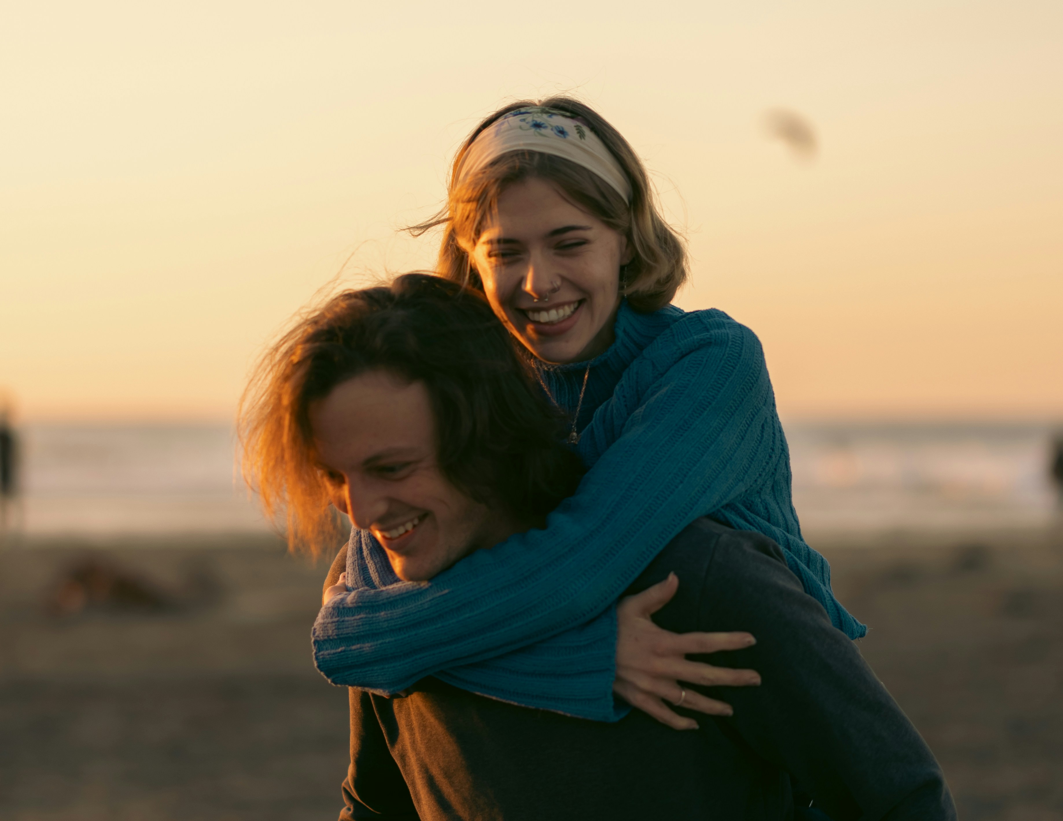 A man carrying a woman on his back on the beach