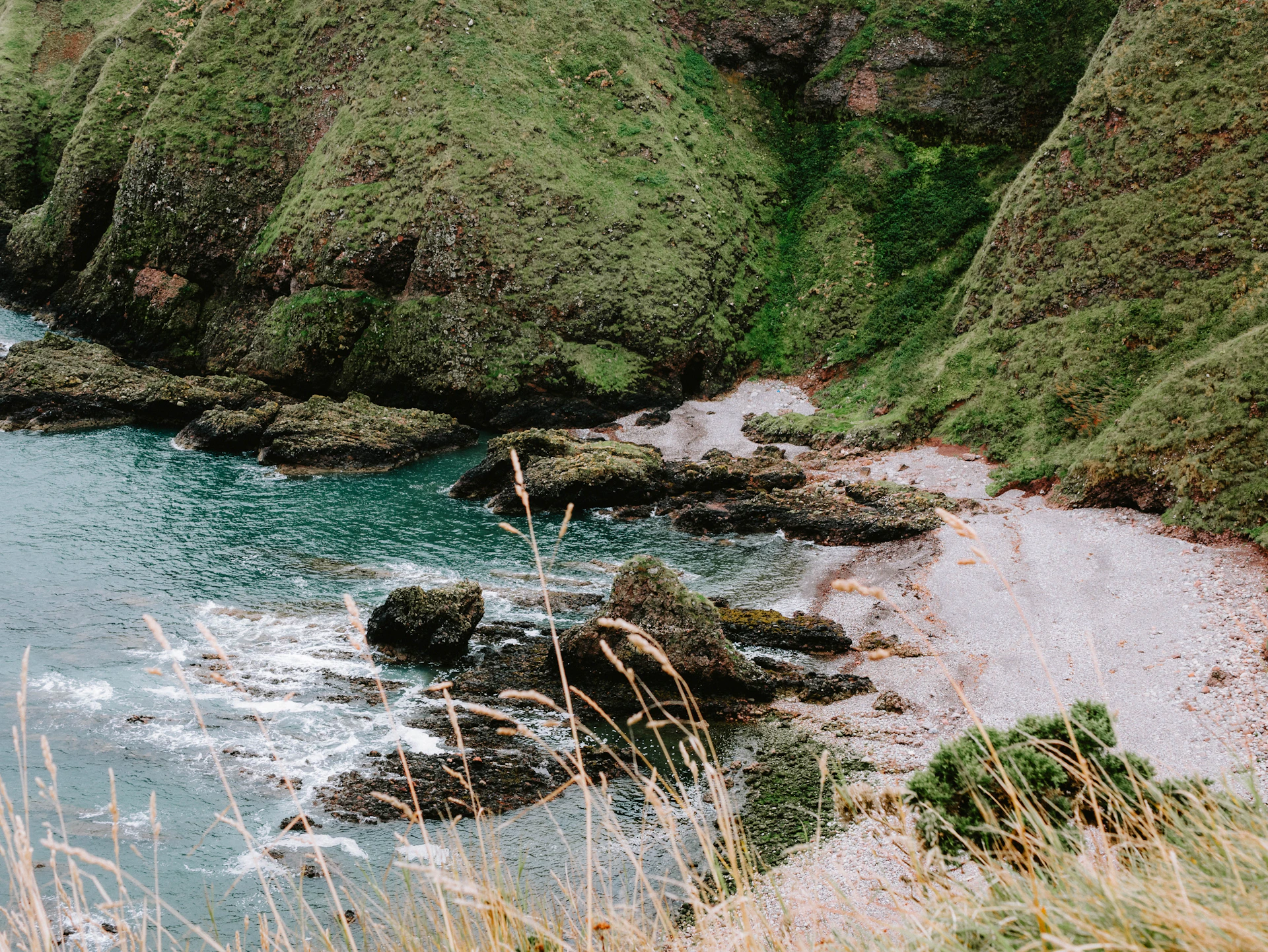 A body of water surrounded by lush green hills