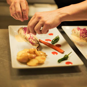 A person is cutting up some food on a plate