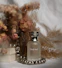 A bottle of perfume sitting next to a vase of flowers