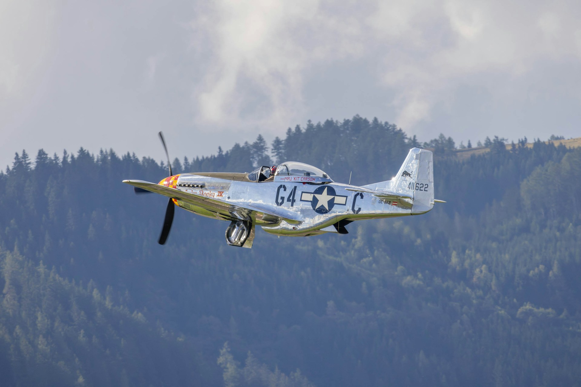 A small airplane flying over a mountain range