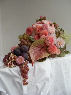 A bouquet of flowers and grapes on a table