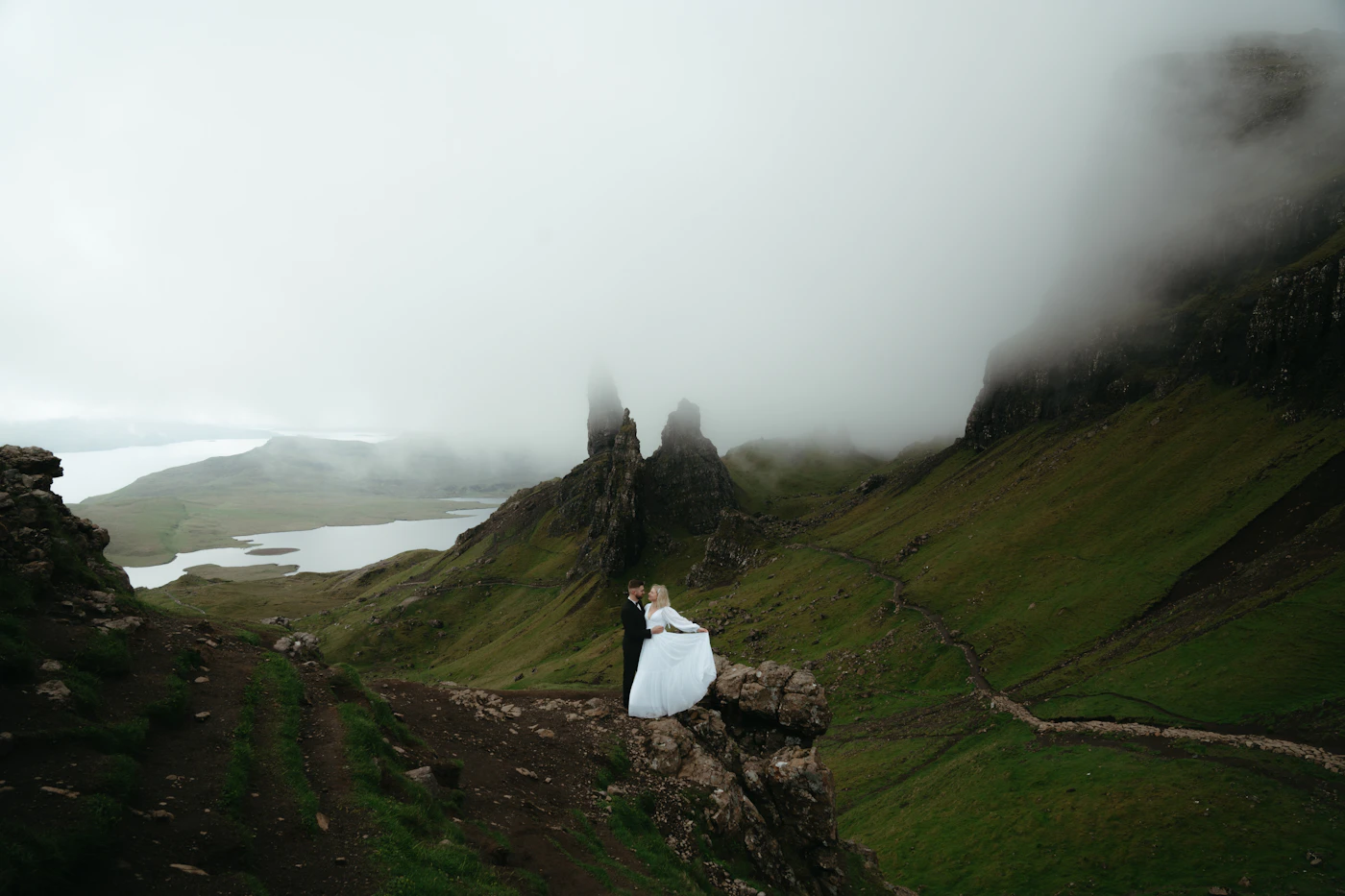 Couple in elopement attire walking hand in hand through a dramatic high-altitude Andean landscape with the volcanic terrain around them