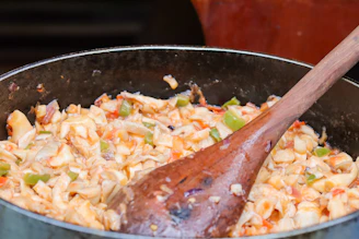 A wooden spoon in a pot of food