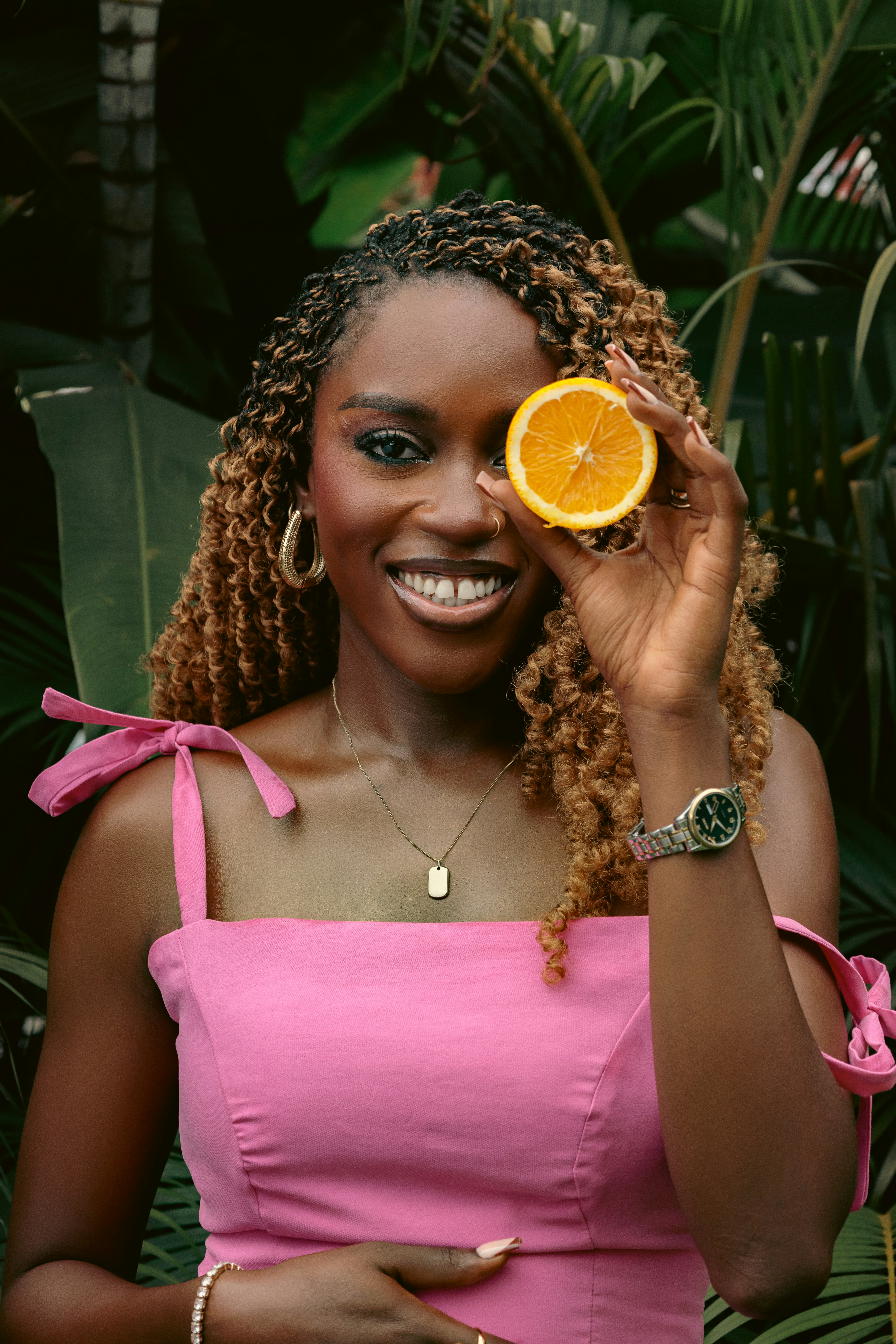 A woman in a pink dress holding an orange