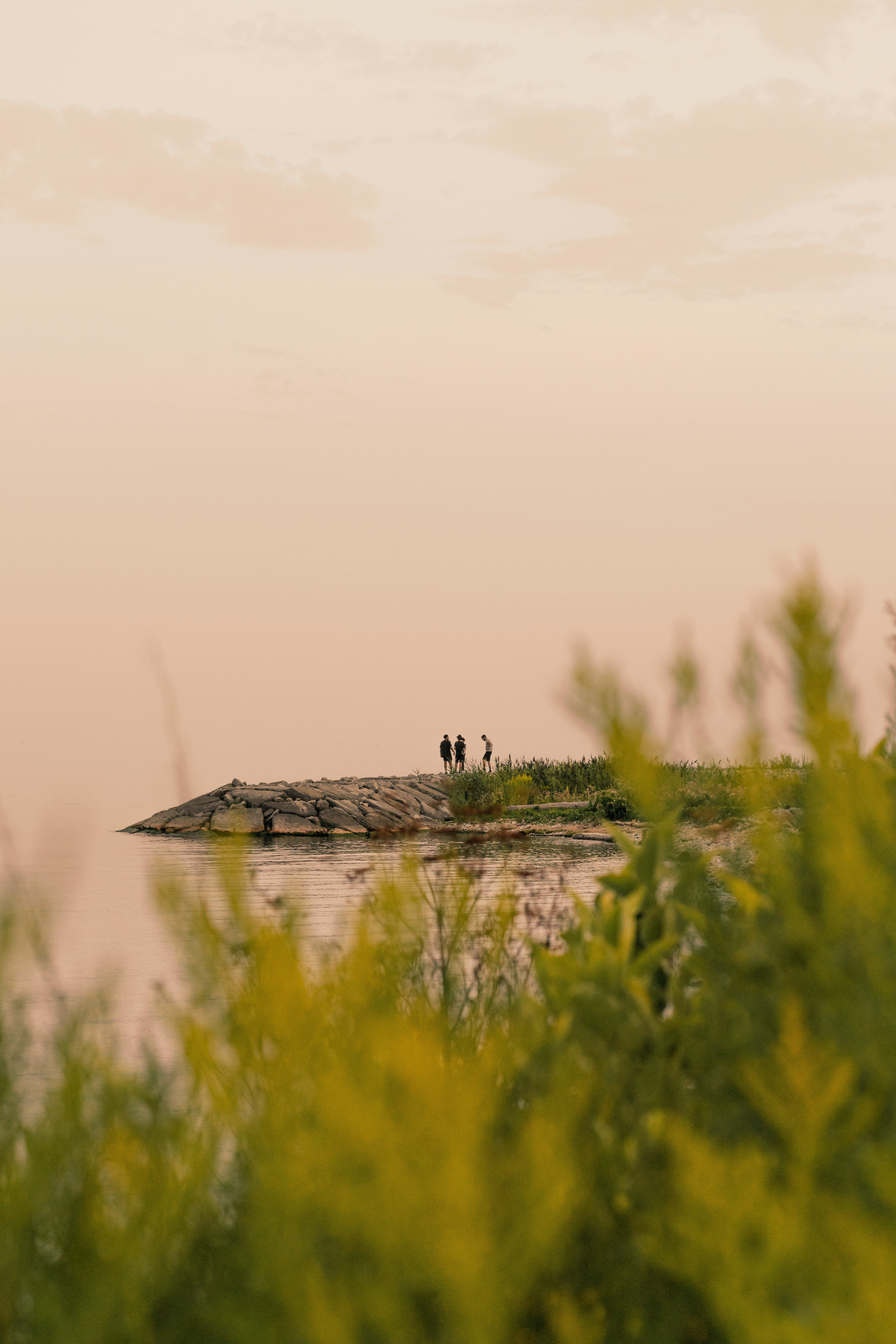 Two people standing on a small island in the middle of a lake