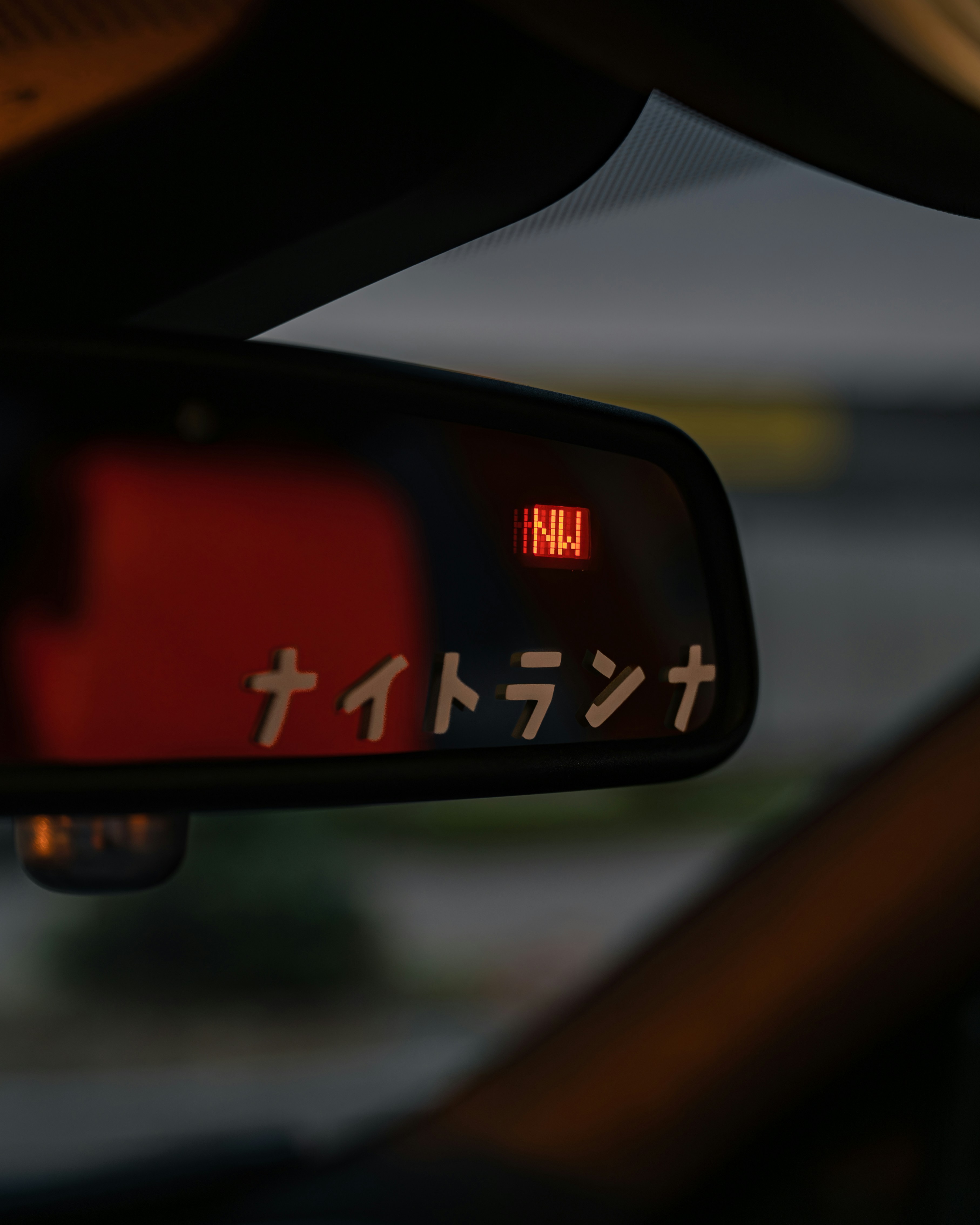 A close up of a car mirror with japanese writing on it