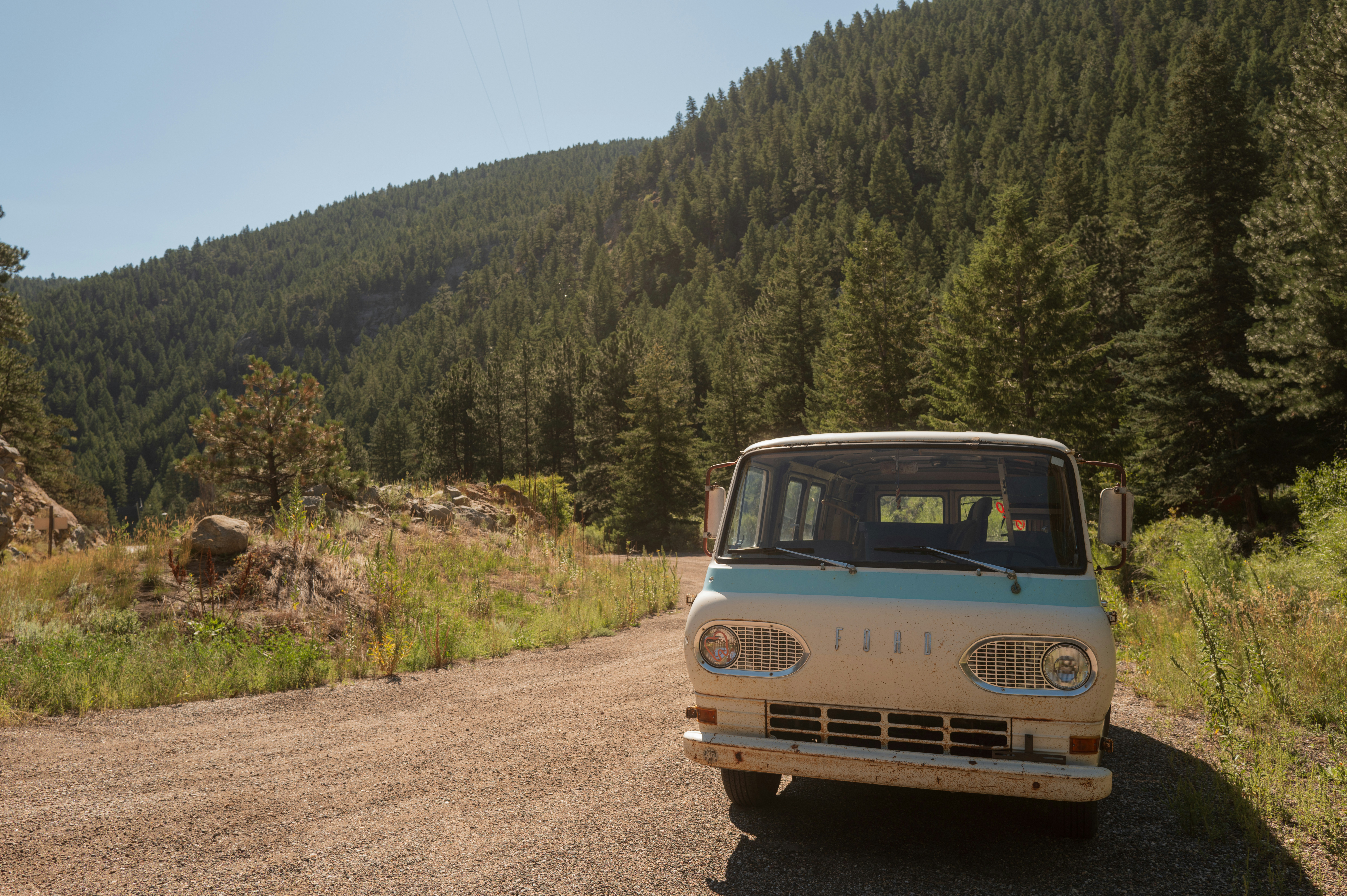 A van is parked on the side of a dirt road
