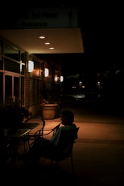 A person sitting in a chair outside of a building