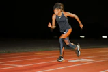 A woman running on a running track at night