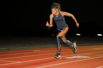 A woman running on a running track at night