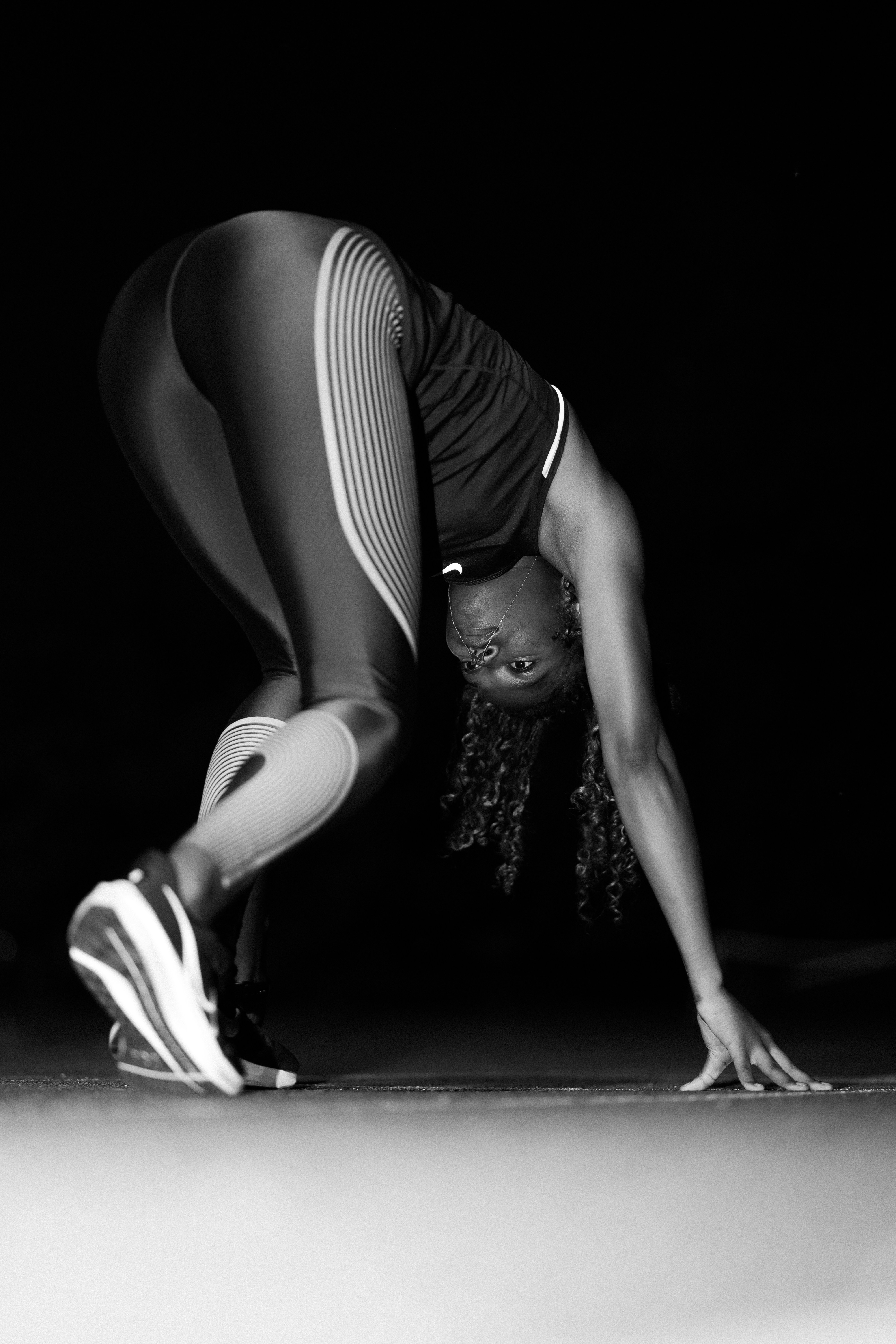 A black and white photo of a woman doing a handstand