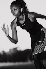A woman in black and white running with a tennis racket
