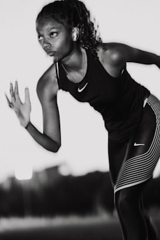 A woman in black and white running with a tennis racket
