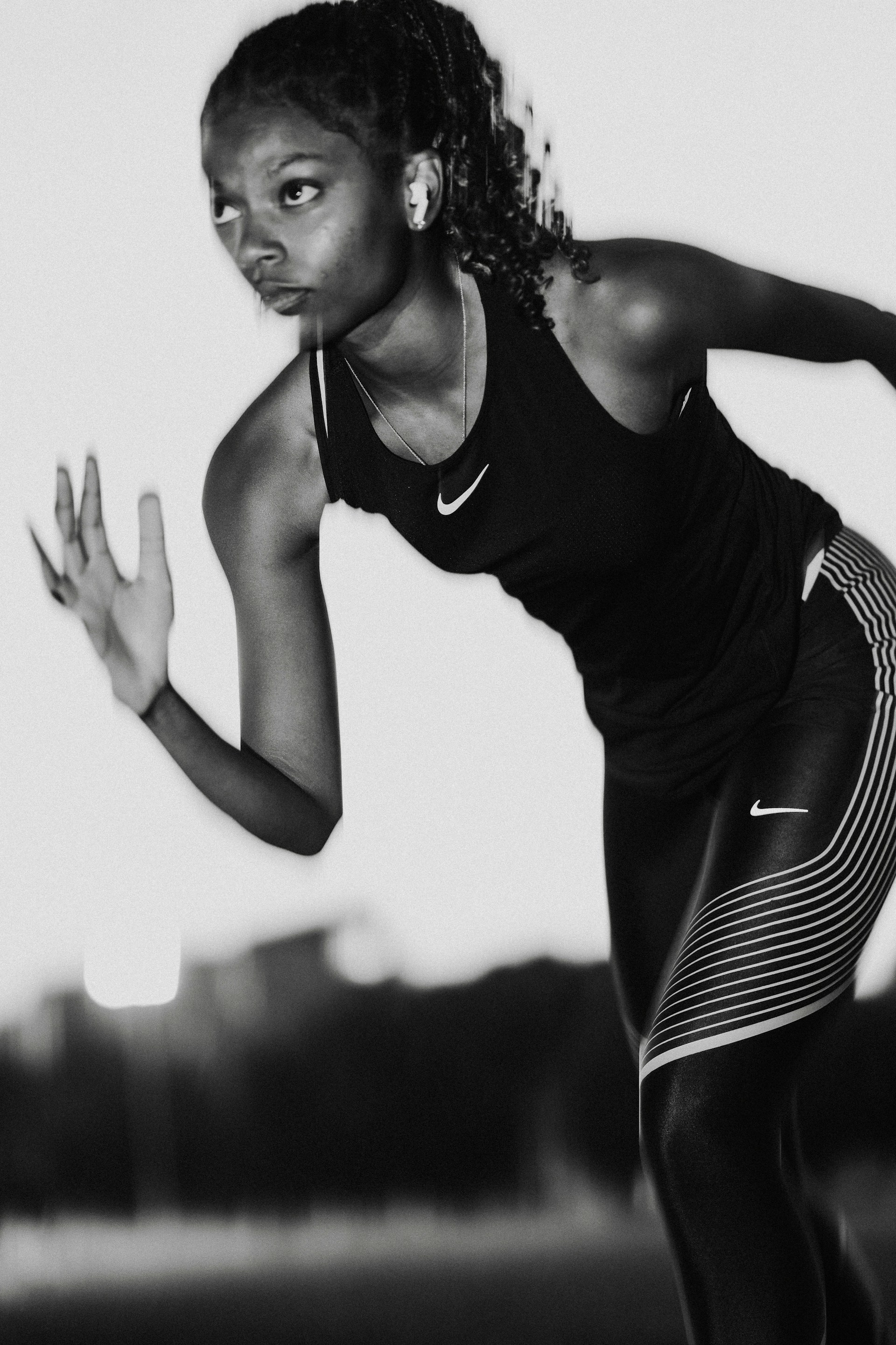 A woman in black and white running with a tennis racket