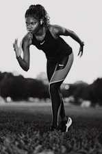 A woman is running in a field of grass