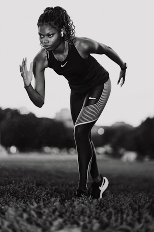 A woman is running in a field of grass
