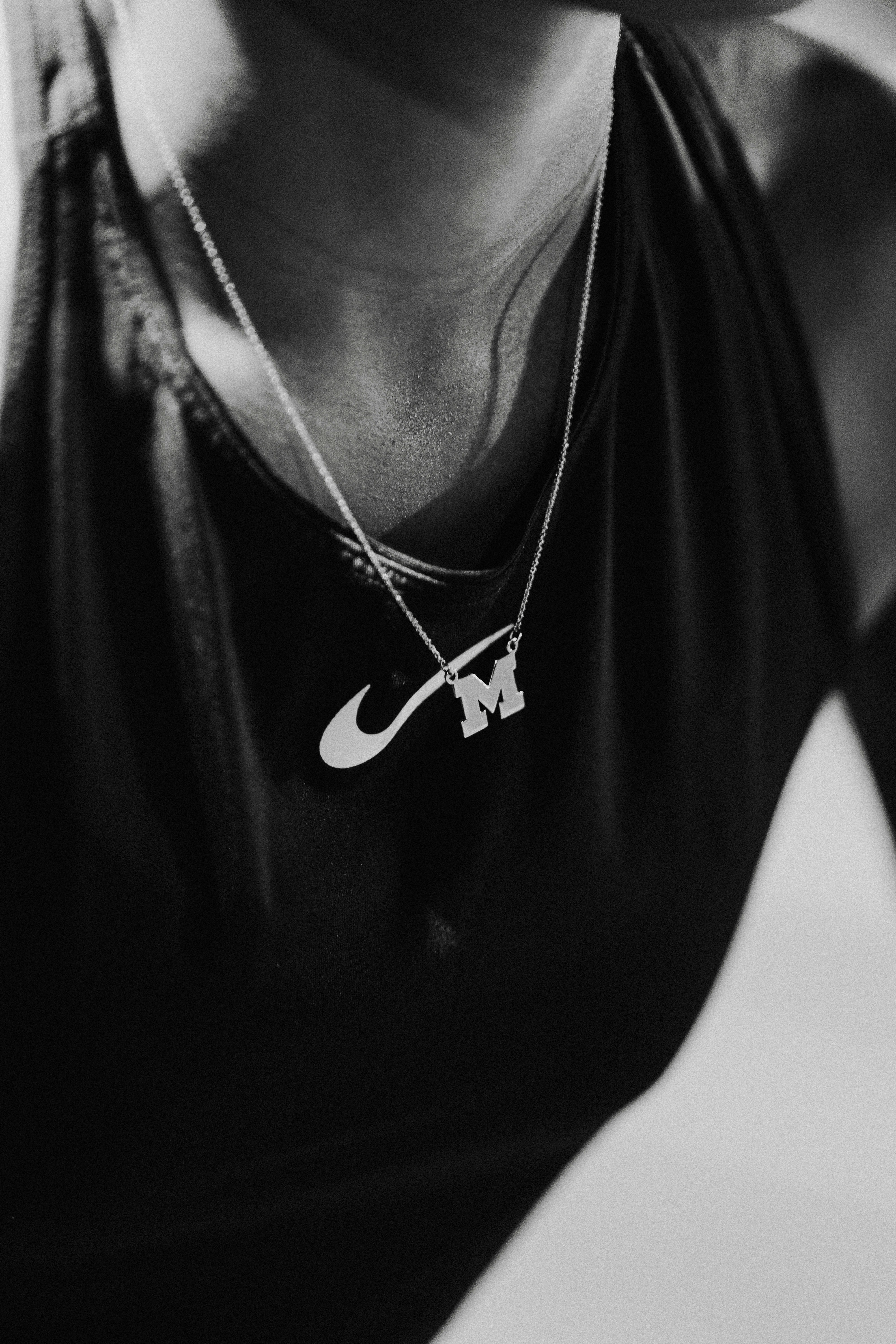 A black and white photo of a woman wearing a nike necklace