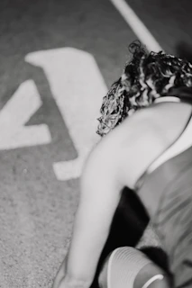 A woman sitting on the ground next to a stop sign