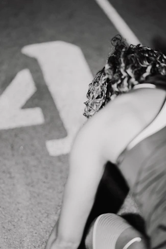 A woman sitting on the ground next to a stop sign