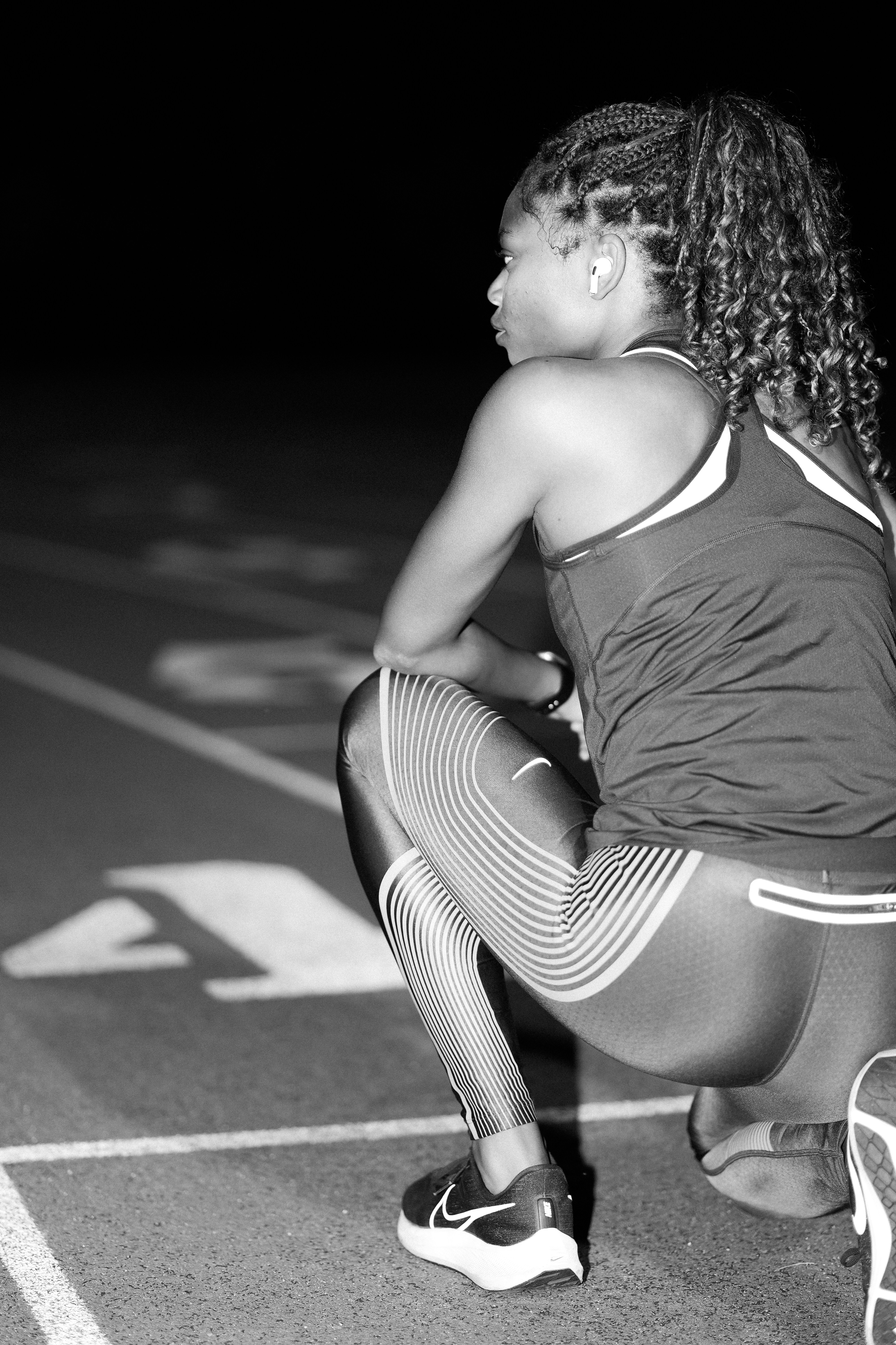 A woman kneeling down on a tennis court