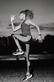 A woman jumping in the air in a field