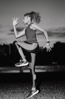 A woman jumping in the air in a field