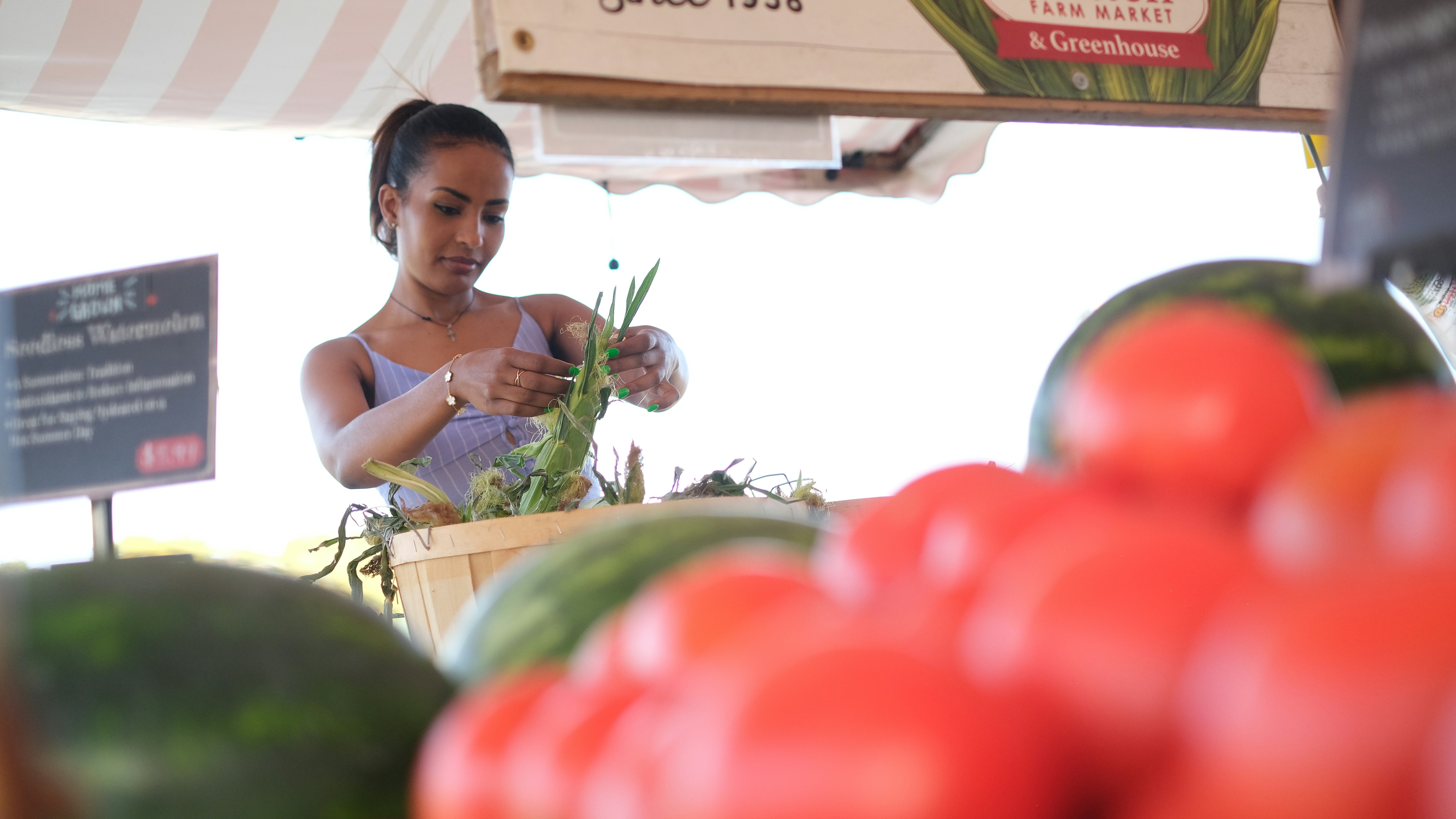 A woman standing in front of a display of vegetables