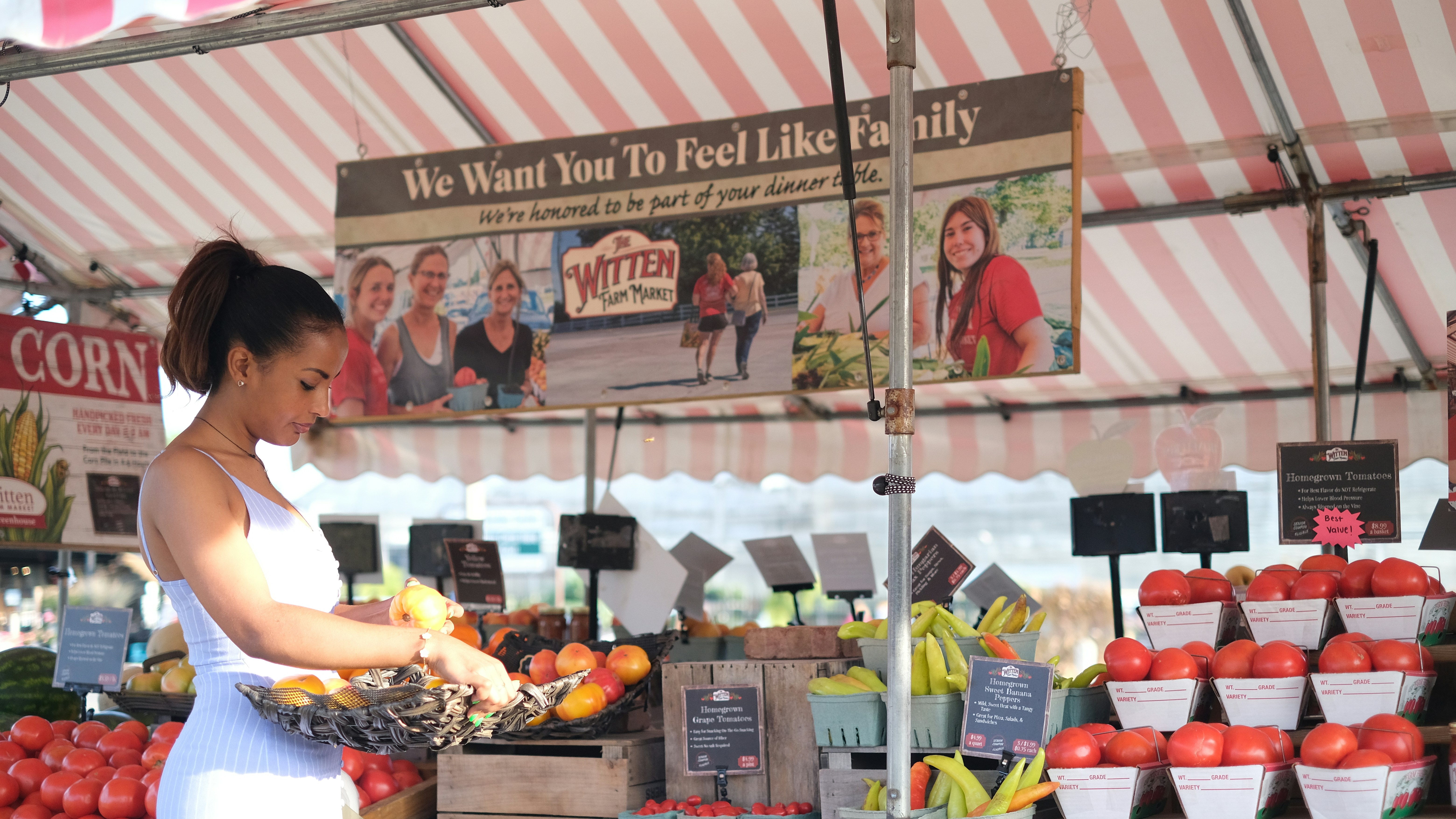 A woman standing in front of a fruit stand