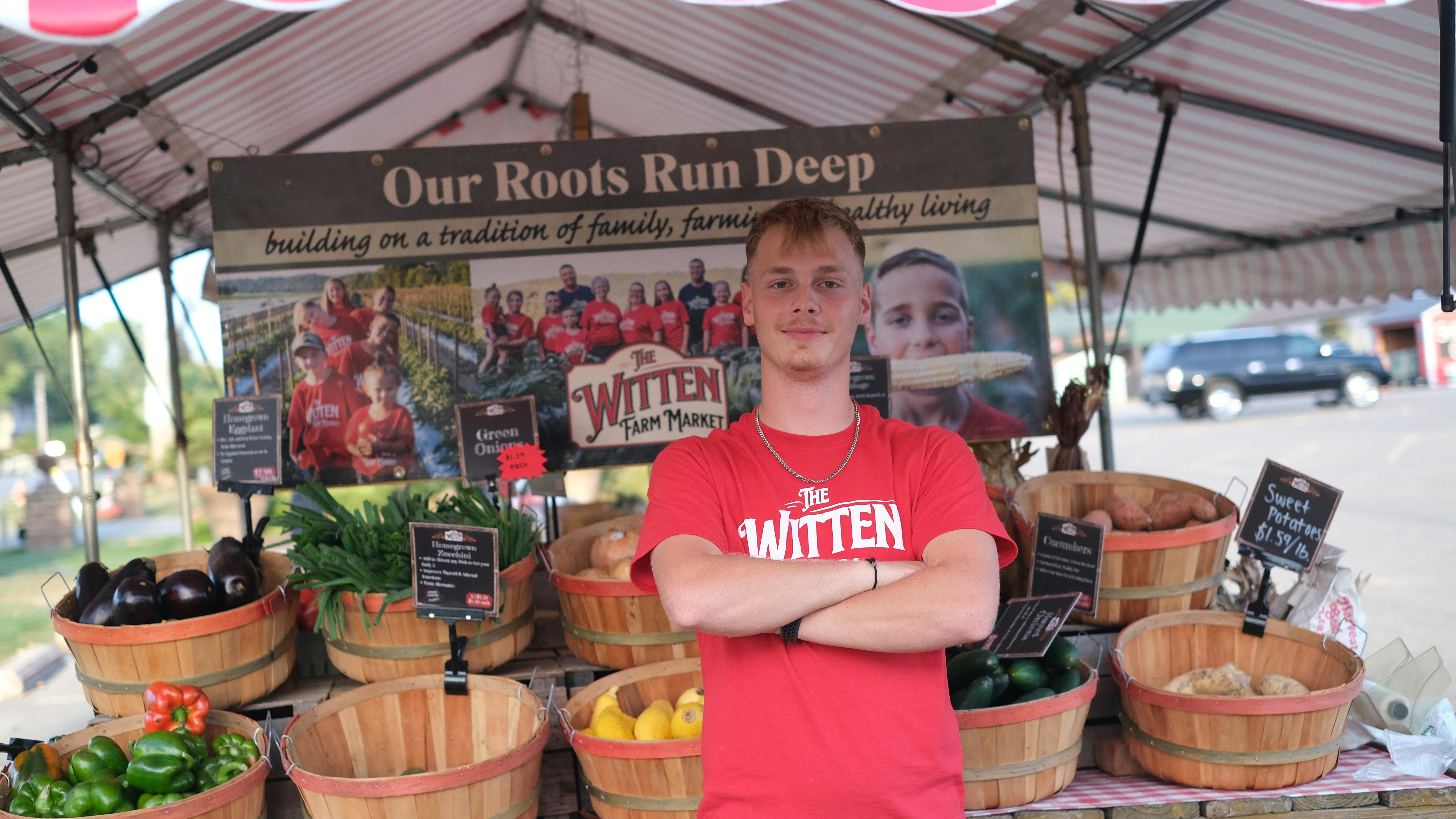 A man standing in front of a display of fruits and vegetables