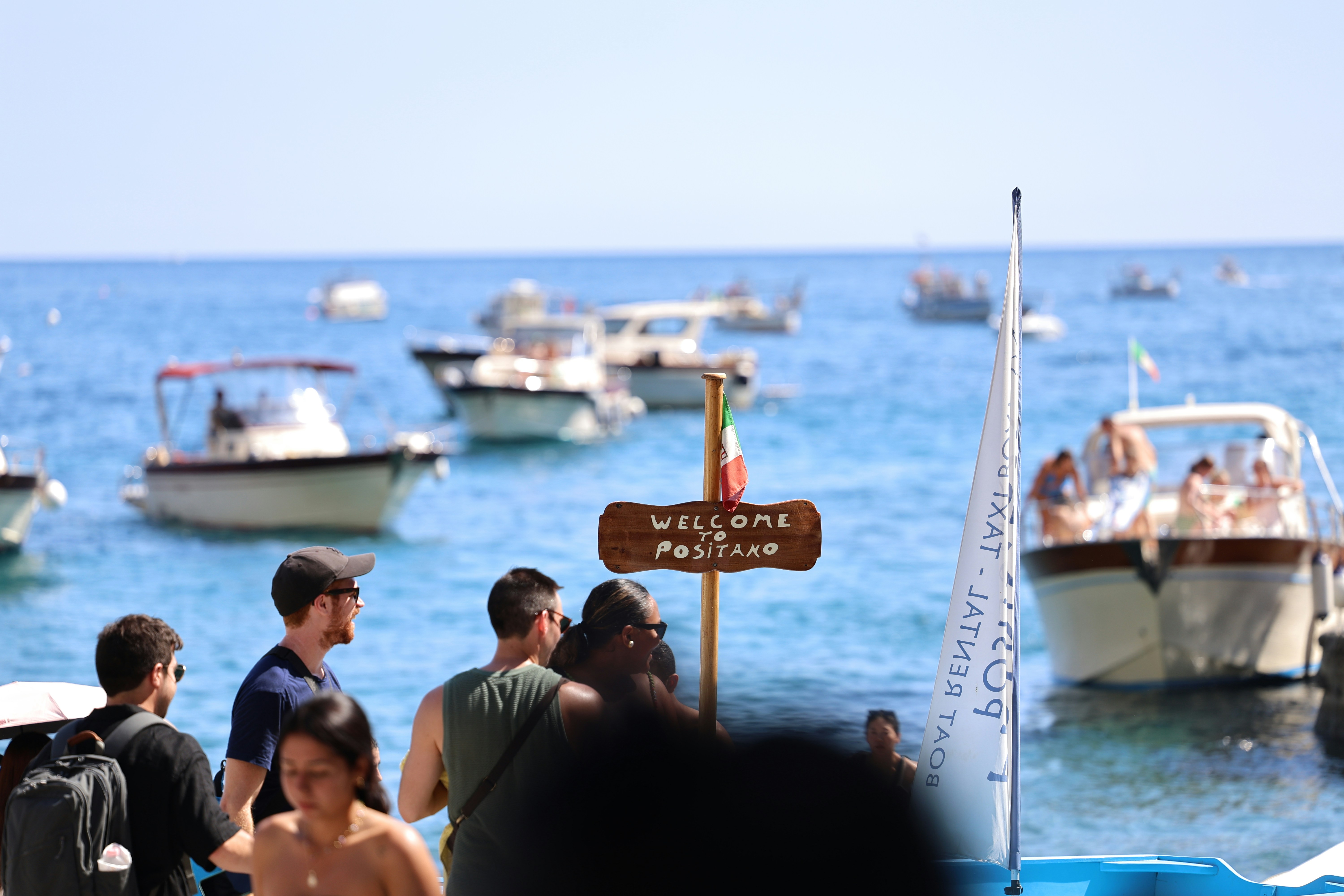 A group of people standing next to a body of water