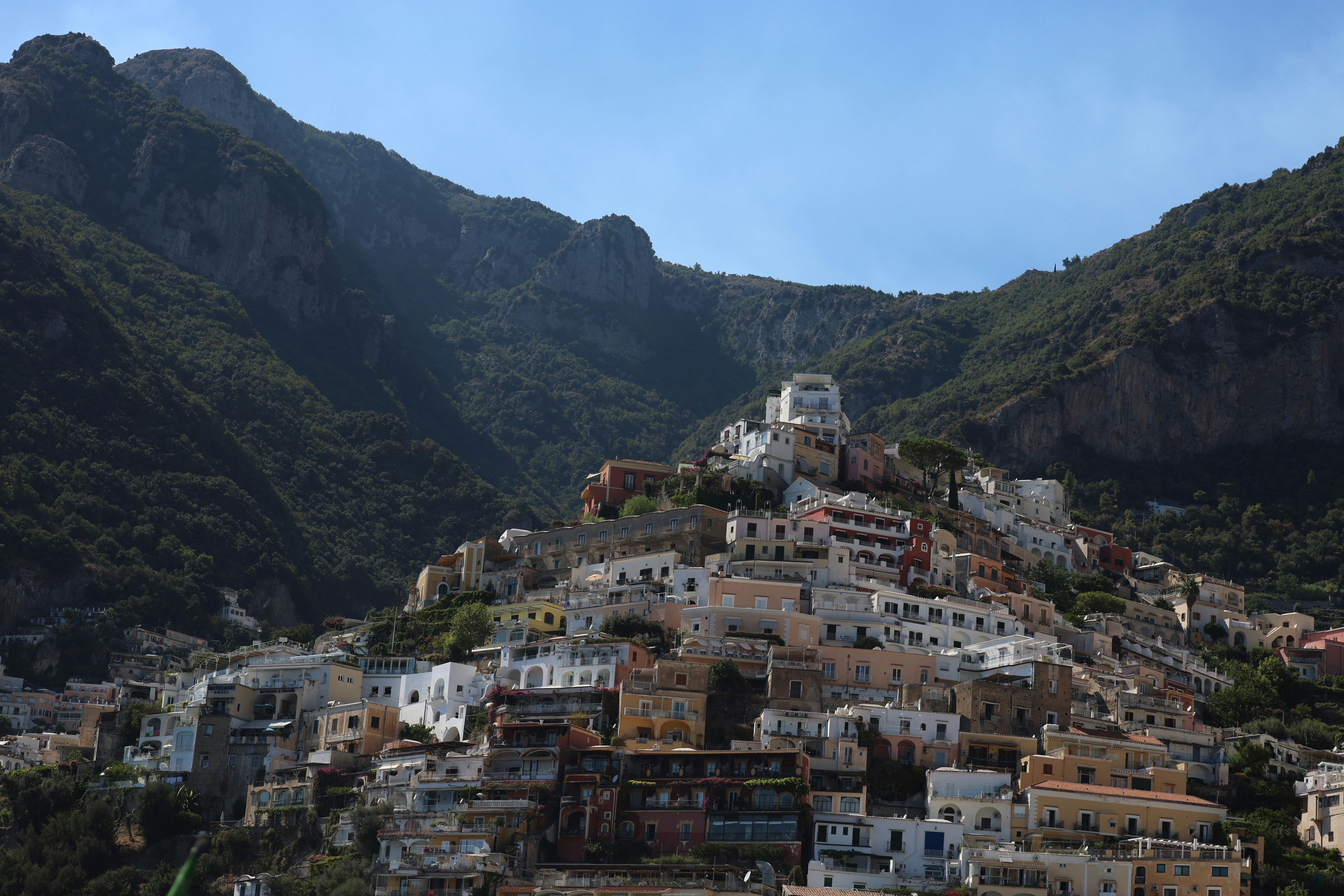A small village nestled on a mountain with mountains in the background