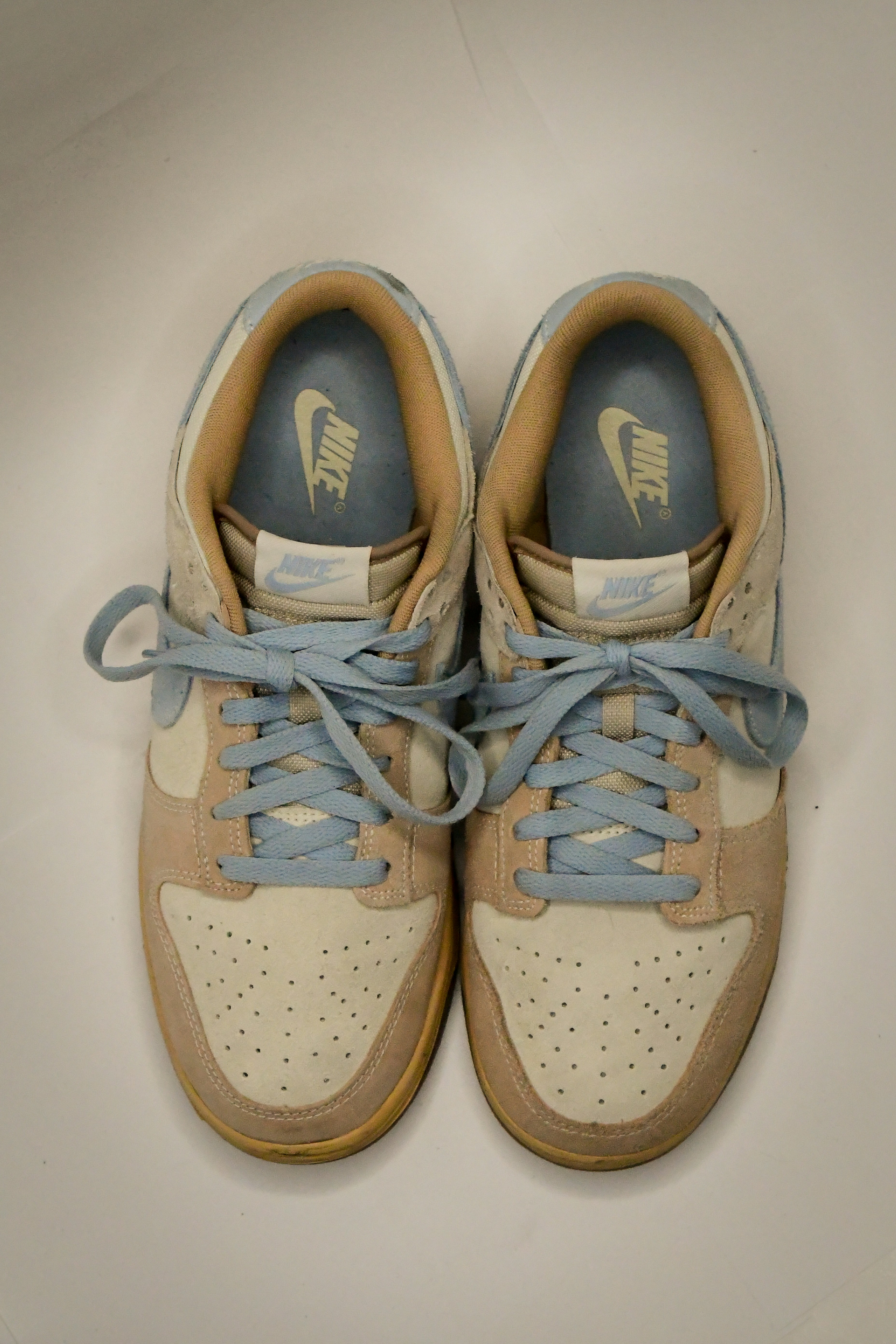 A pair of sneakers with blue laces on them