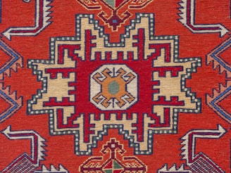 A red rug with an intricate design on it