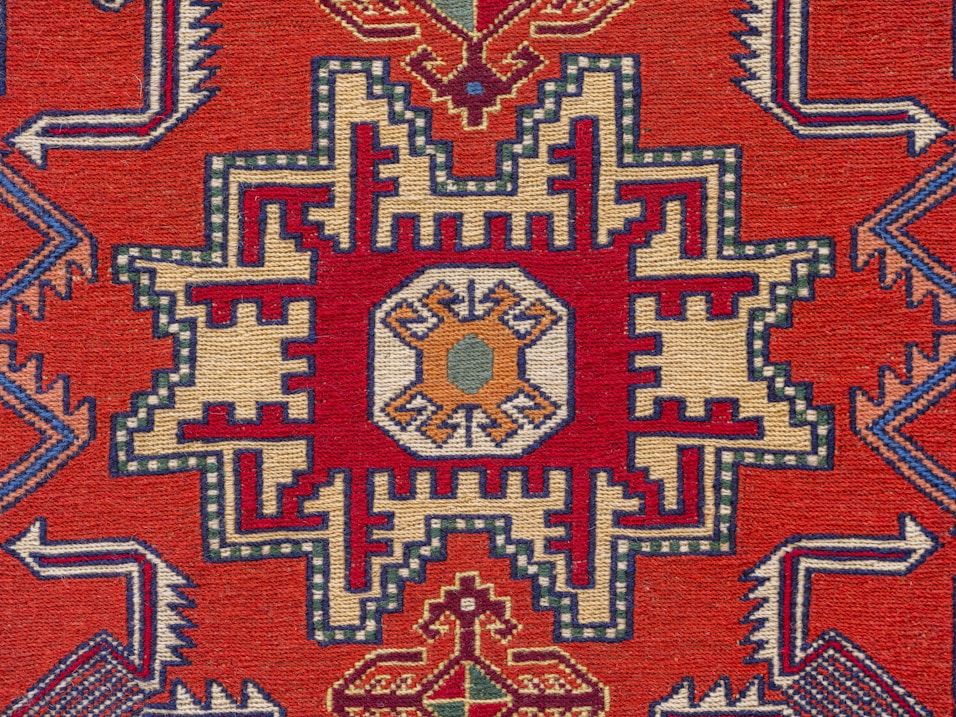 A red rug with an intricate design on it