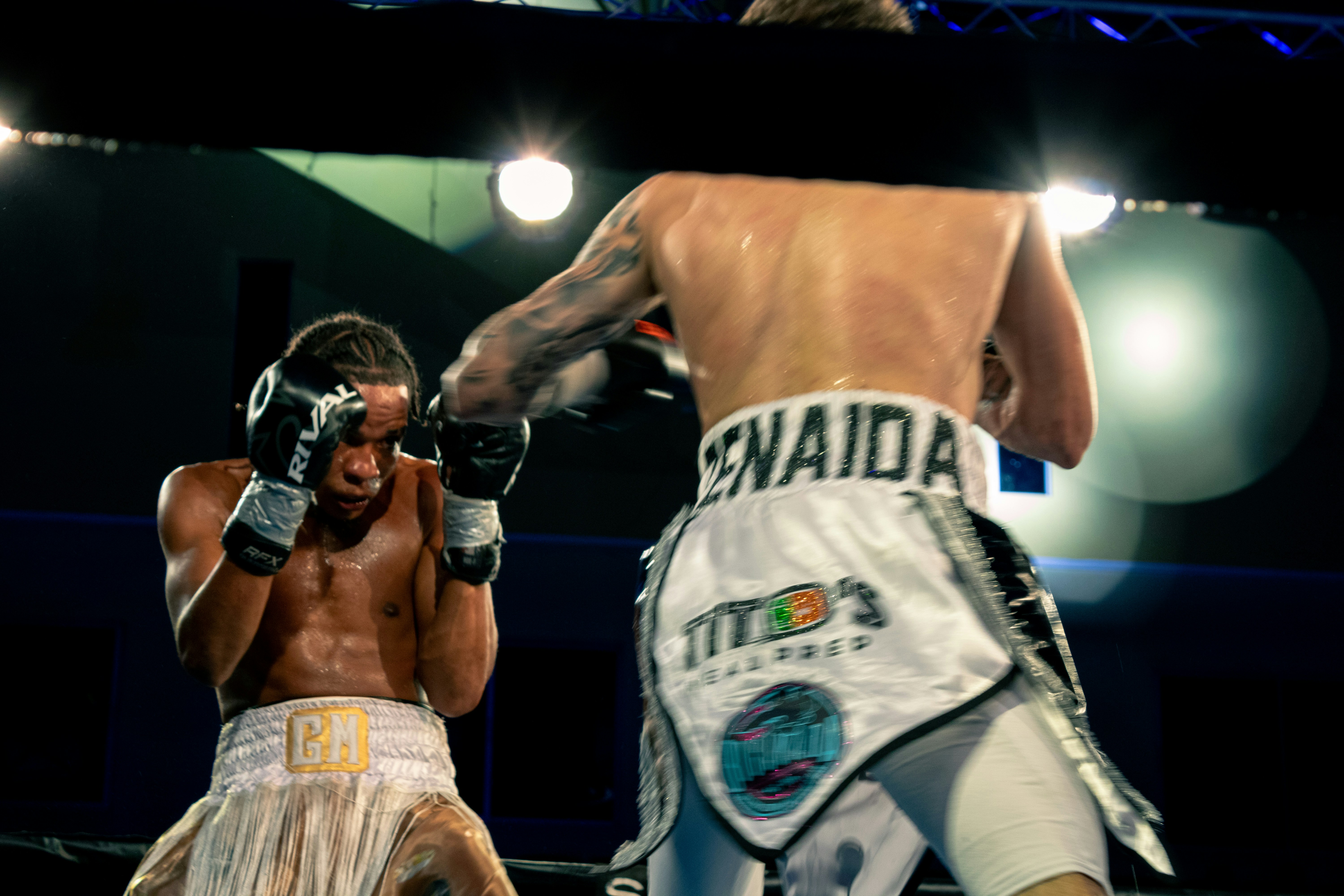 Two boxers in ring during championship fight under bright lights