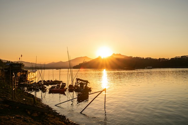 The sun is setting over a body of water — Luang Prabang, Laos