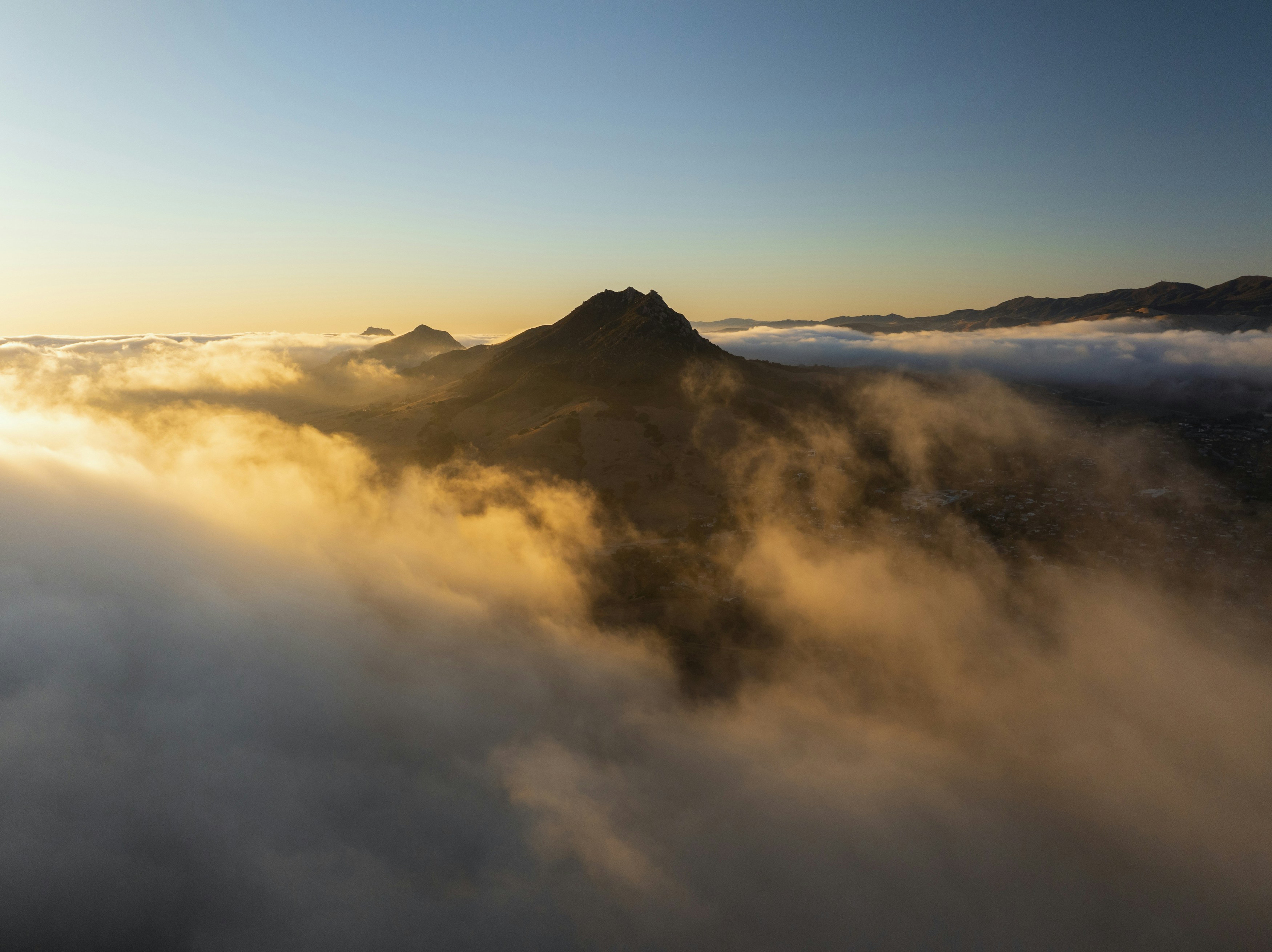 A view of a mountain covered in clouds