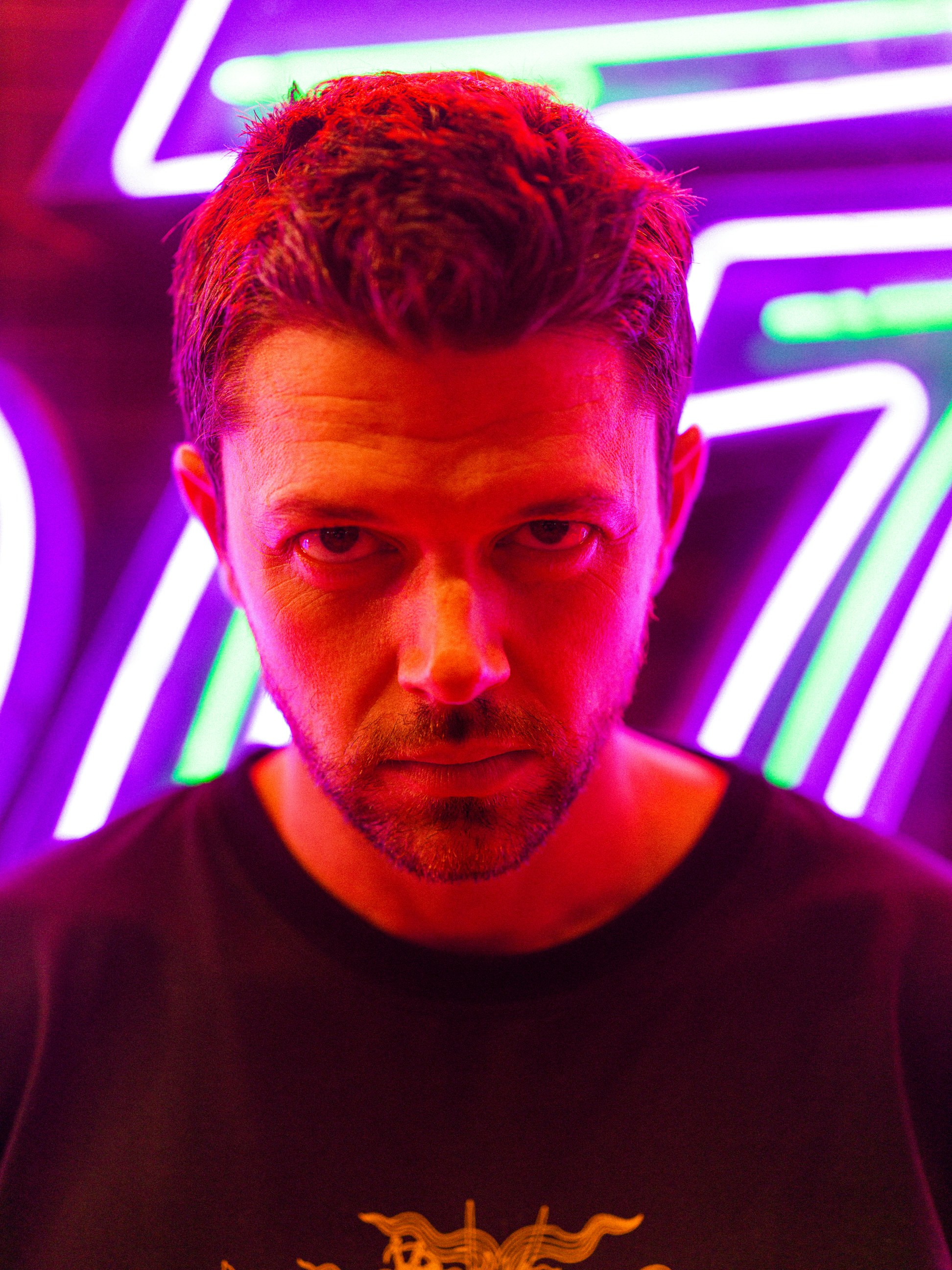 A man standing in front of a neon sign