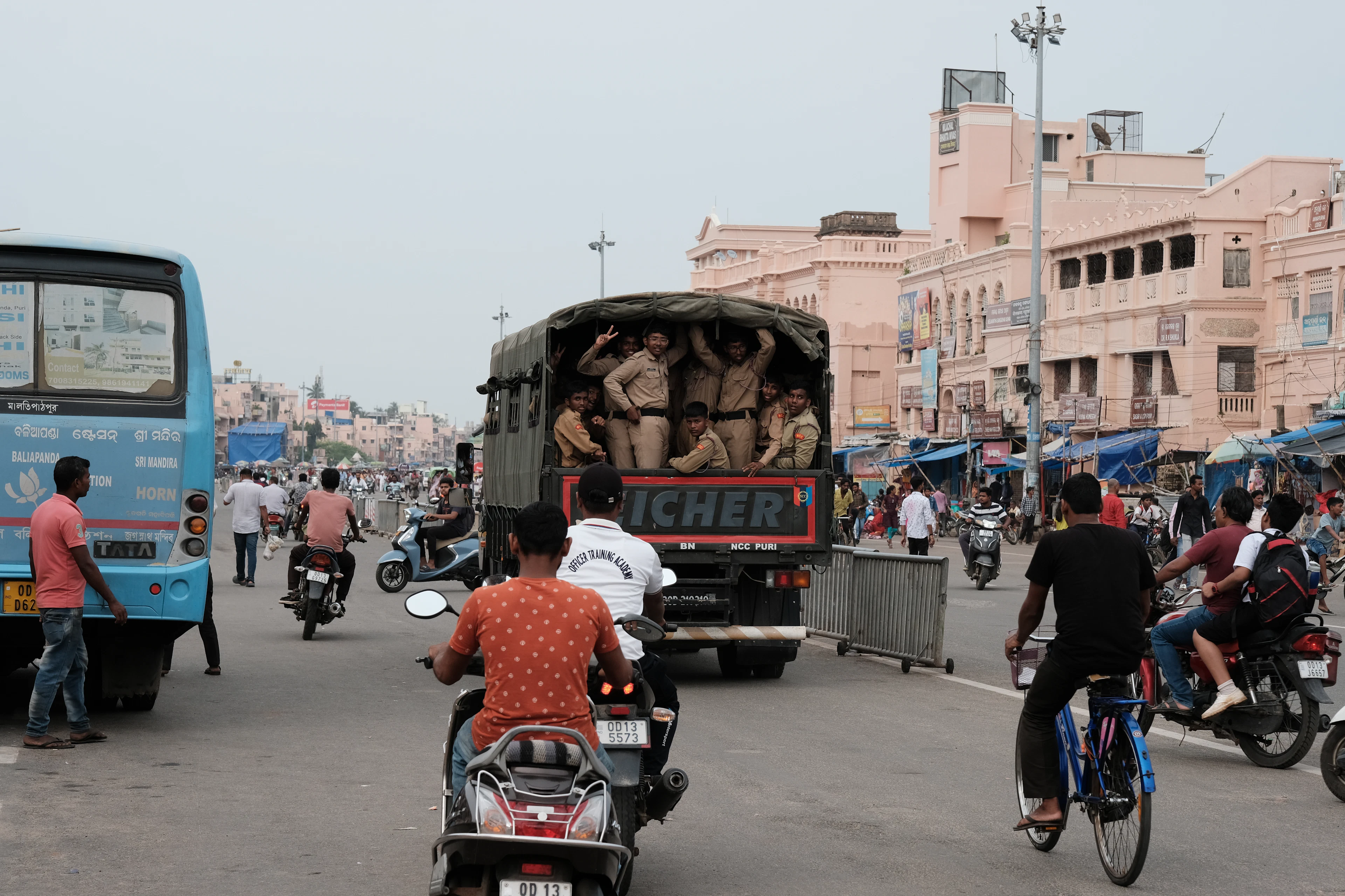 Army truck carrying soldiers on a busy city road