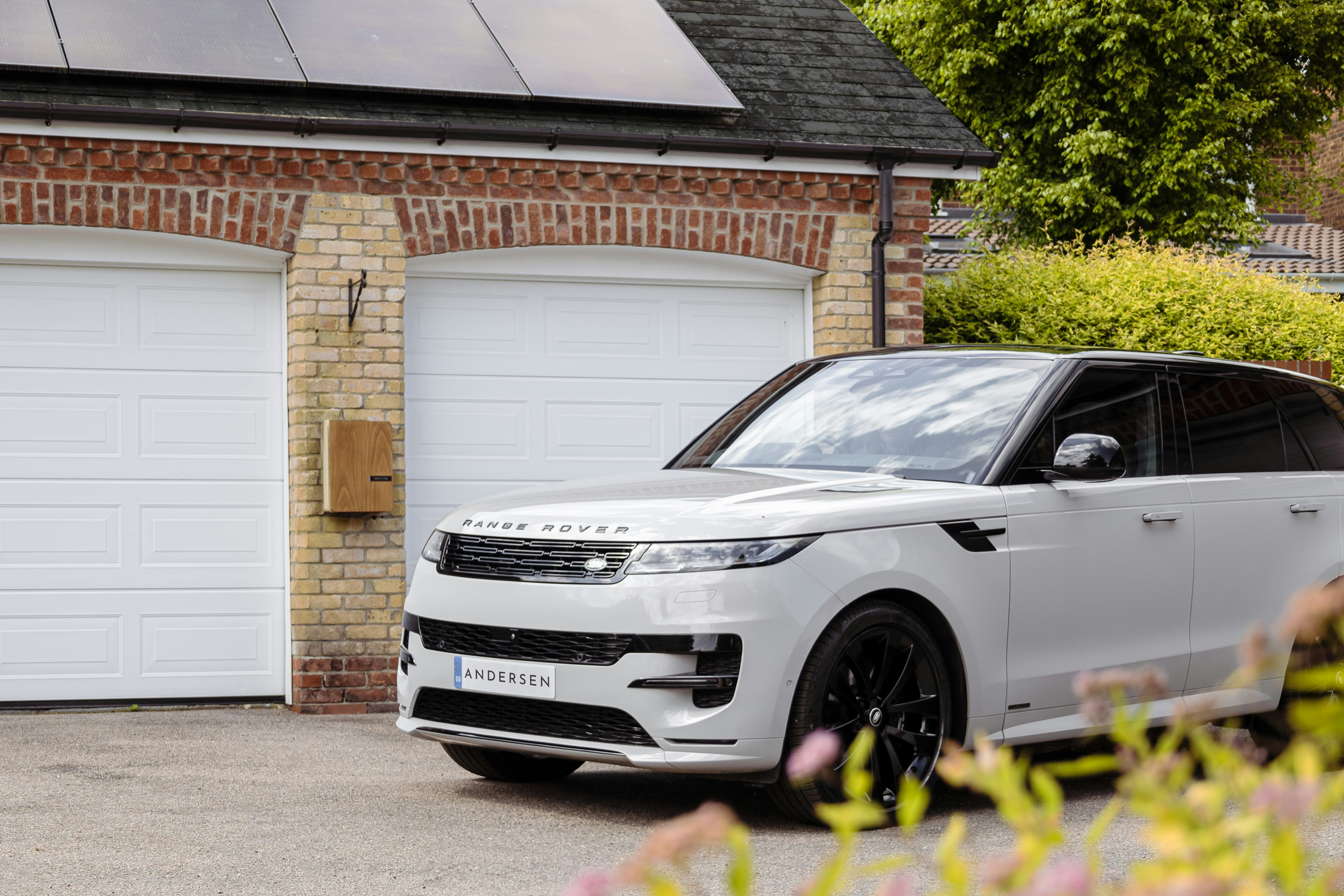 A white range rover parked in front of a house